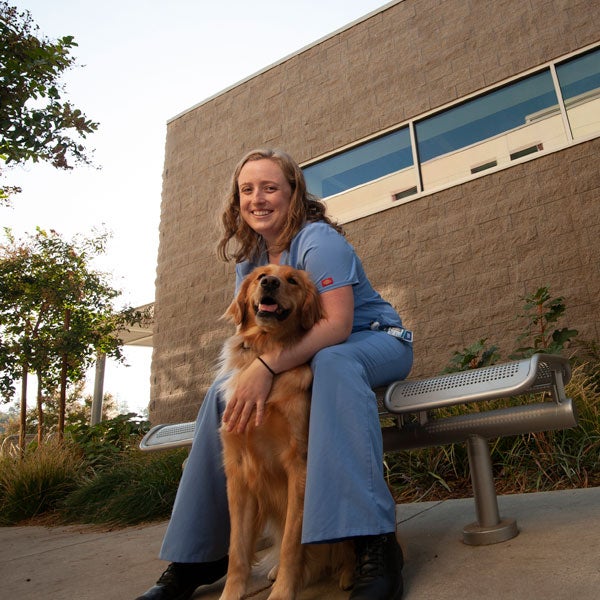 A veterinary student cares for a dog outside of the TV School of Veterinary Medicine