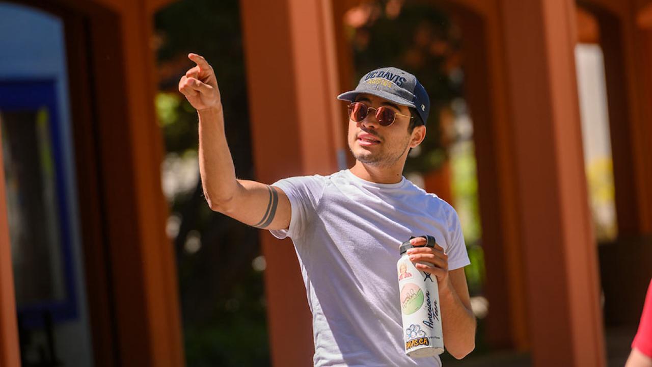 male tour guide pointing out a TV campus landmark