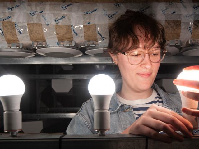 A female TV researchers examines some new lighting technology
