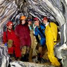 Five TV researchers inside marble rock formations of cave
