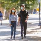 Students with masks walk through the sunlit TV campus.
