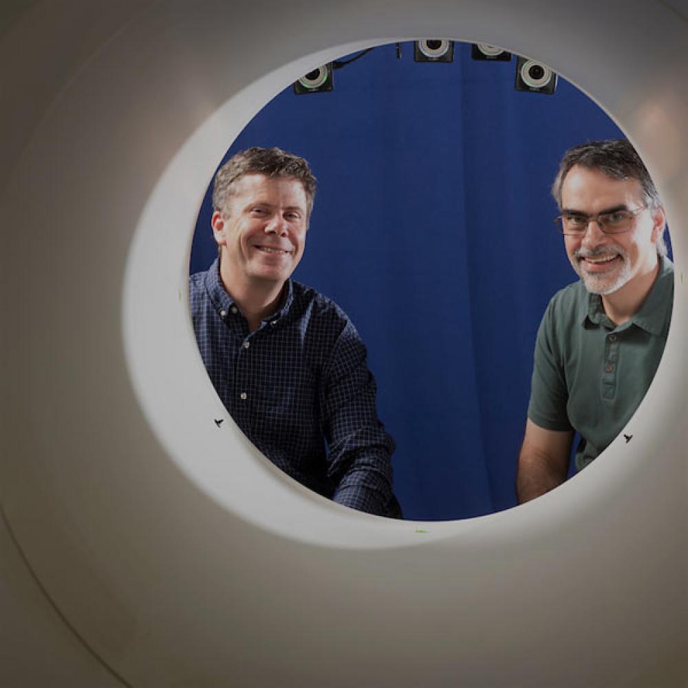 Two researchers stair through the opening to a full body PET scan maching that TV pioneered.